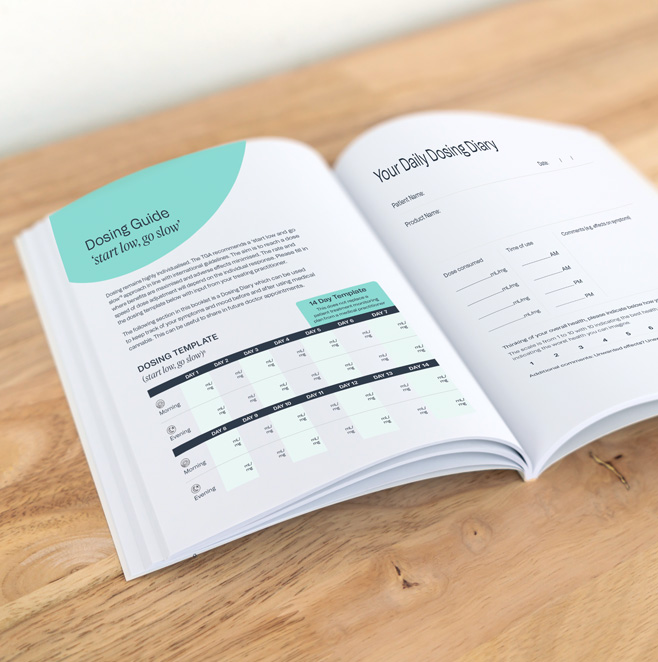 Medical cannabis textbook lying open on a table, displaying pages "dosing guide" and "your daily dosing diary".