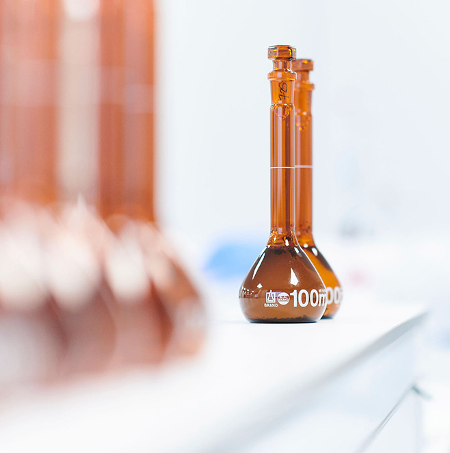 Two brown medicinal cannabis bottles stand apart from a row of bottles.